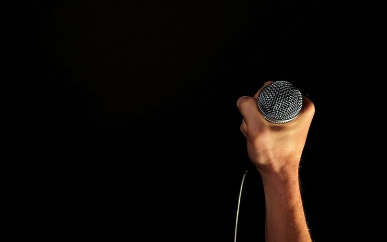 a person holding a mic symbolizing how one should be courageous to be vulnerable